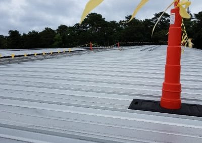 Photo of an orange caution cone on a commercial rooftop