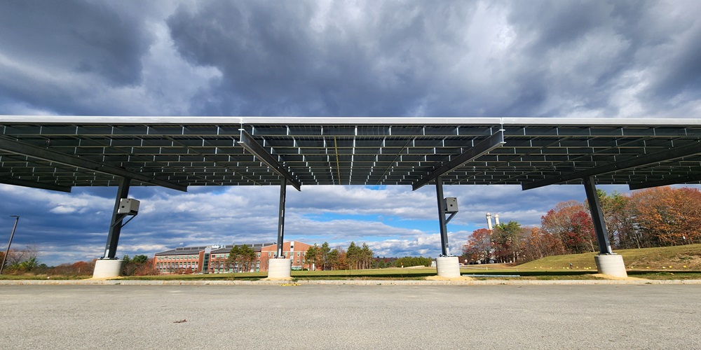 A solar carport overlooks a grassy field