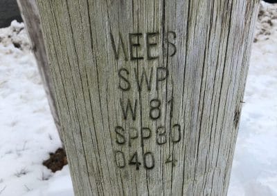 A power pole branded with information about its location