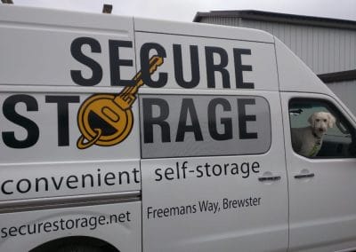 A photo of a work van with a very friendly doggo in the passenger seat