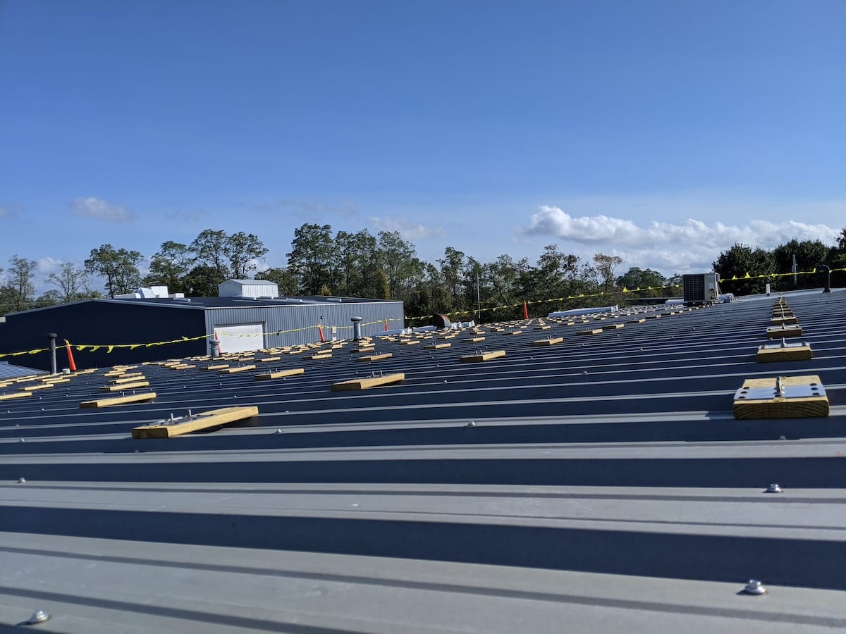 Footings and flashing being bolted down in a commercial solar install