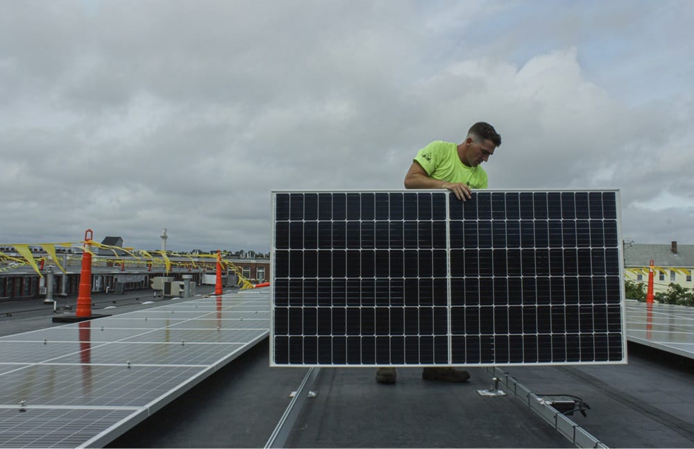 Man installing solar panel on rooftop