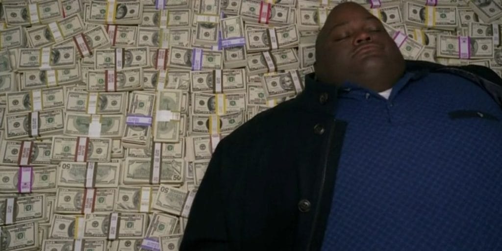 Guy lies down on fat pile of cash