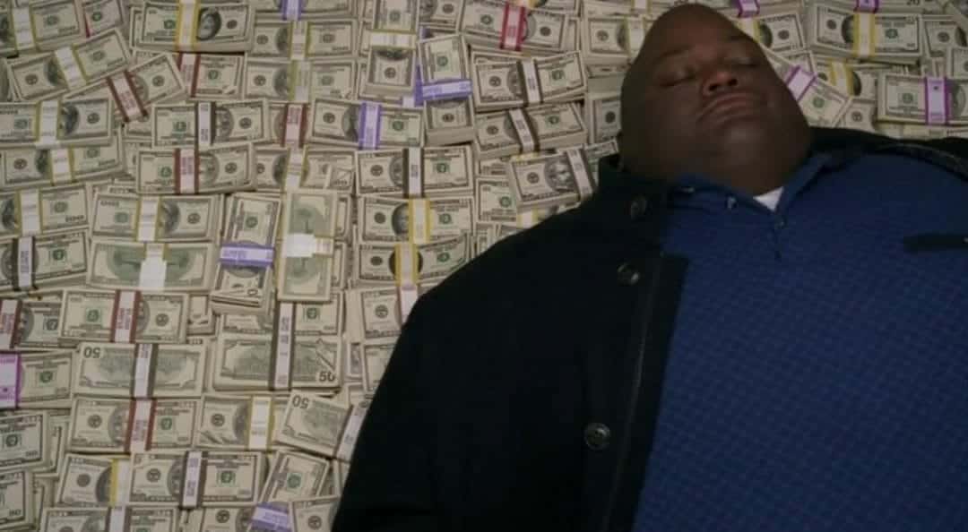 Guy lies down on fat pile of cash