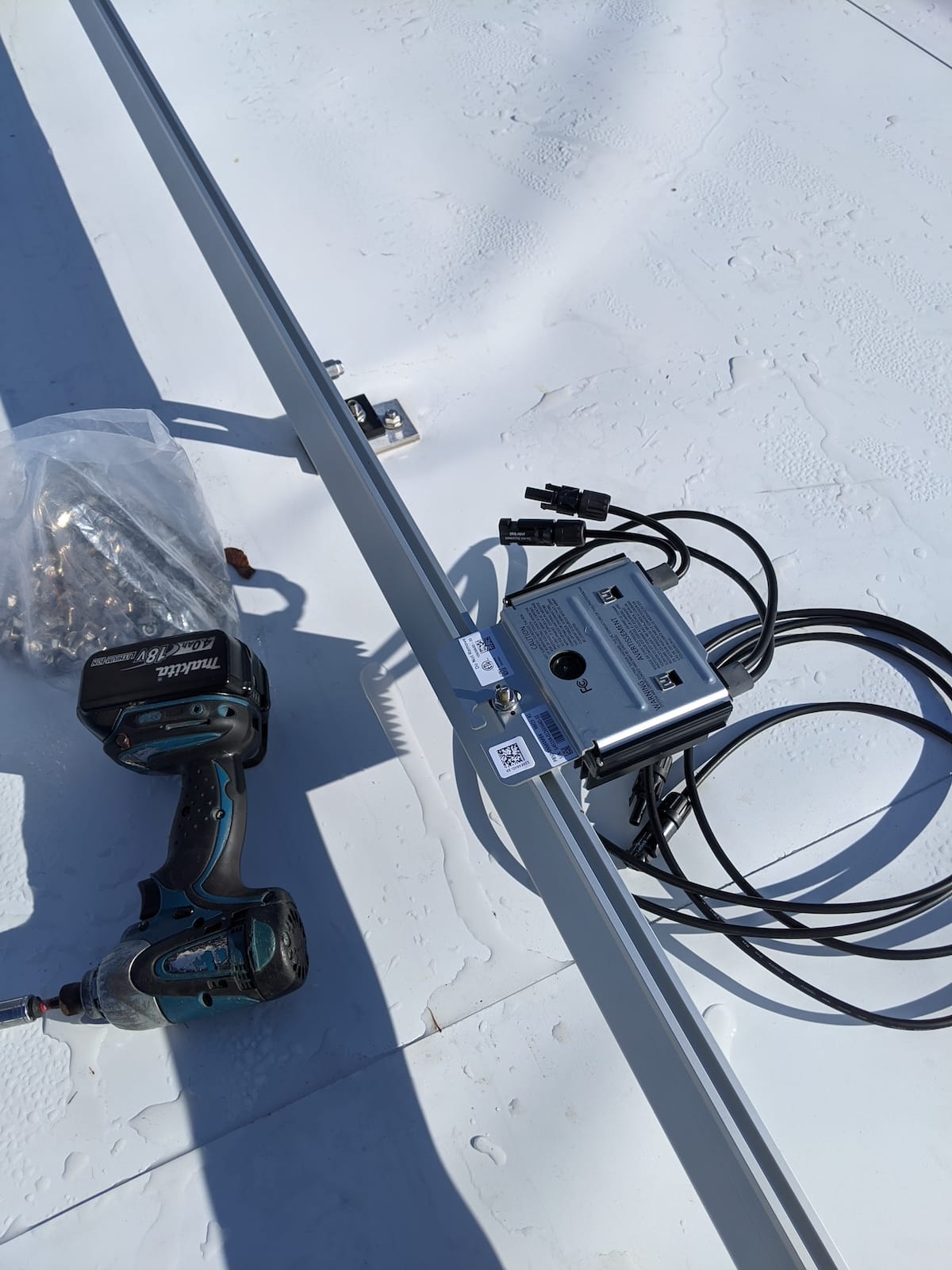 Electric impact wrench installs fasteners to attach optimizer to extruded rail