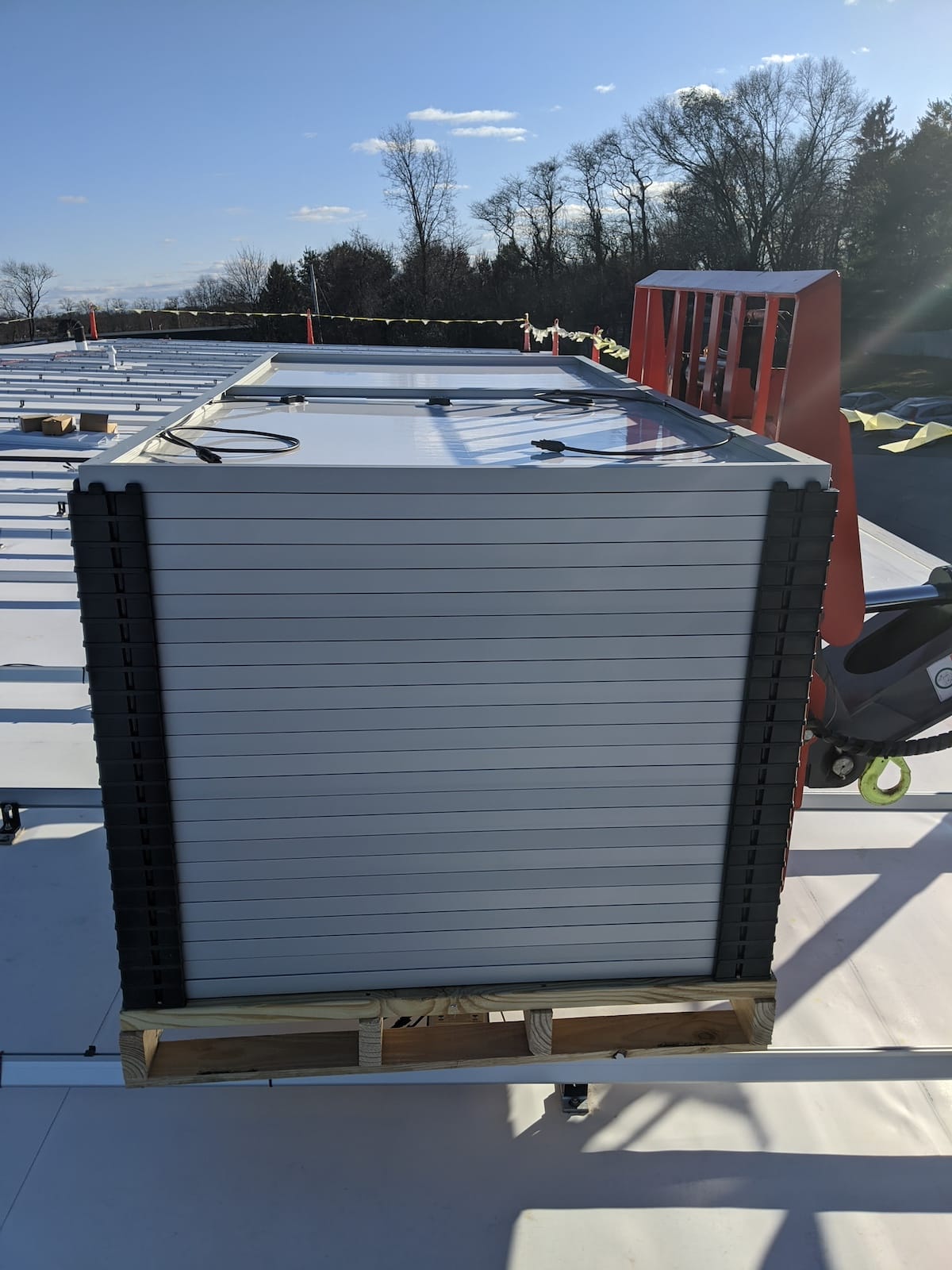 Forklift raises pallet of sola panels to roof