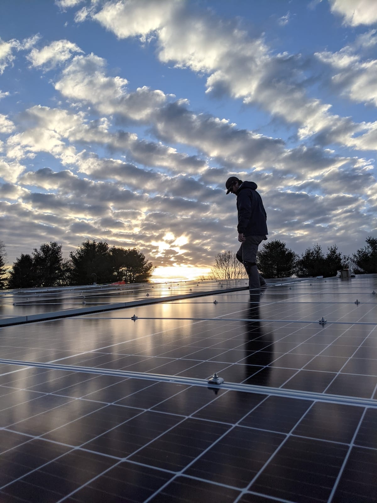 Picturesque shot of sunset over newly-finished commercial solar installation on roof