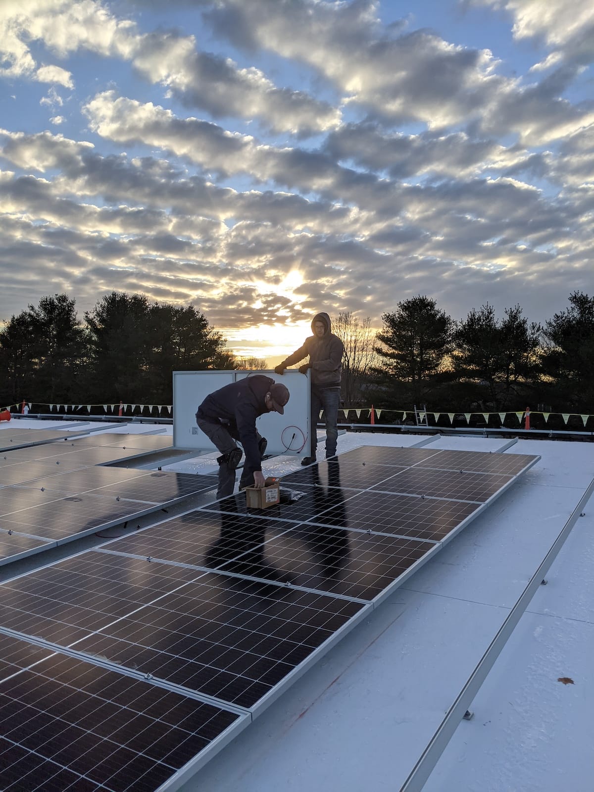 Installation of solar panel on roof at sunset