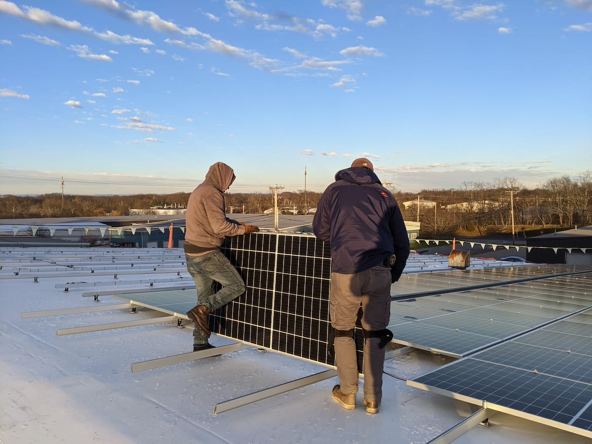 The installation team, placing solar panel on racking